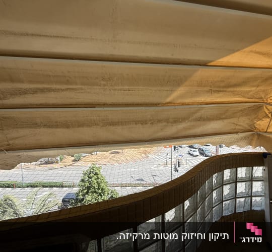 מרפסת עם סוכך בד מעל נוף עירוני
